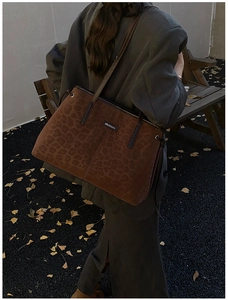Detail of leopard print tote bag with metal logo on a stylish autumn fashion background