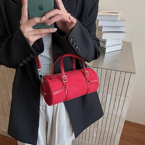 Modern red cylinder bag in matte faux suede shown in a lifestyle street style shot