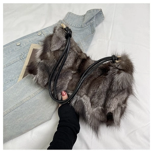 Detail view of plush faux fur shoulder bag in dark brown with black leather strap