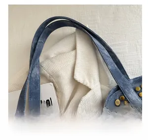 Gros plan d'un sac cabas en jean vintage avec des rivets métalliques dorés décoratifs