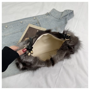 Detail of plush faux fur shoulder bag with leather handle, gold hardware and zipper closure