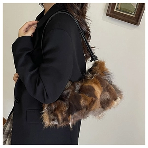 Close-up of fluffy faux fur patchwork shoulder bag with sleek black strap for winter style