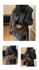 Detail of leopard print tote bag featuring gold interlocking rings and beaded tassel charm