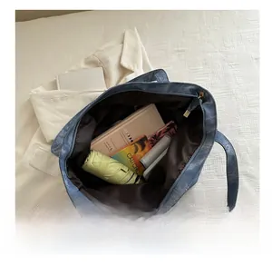 Vue intérieure du grand sac cabas en denim avec fermeture éclair dorée et contenu