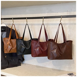 Détail de quatre sacs fourre-tout en cuir tressé avec petites pochettes zippées assorties