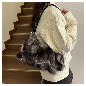Close-up of a plush long-pile faux fur shoulder bag with black leather straps