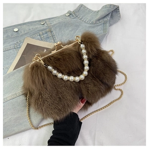 Detailed close-up of brown faux fox fur bag with pearl handle and golden chain strap
