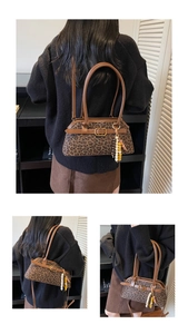 Detail of leopard print shoulder bag with brown leather straps and beaded charms
