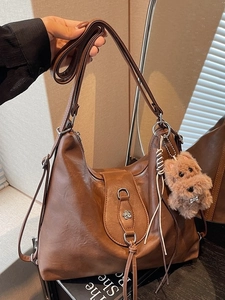 Vintage brown leather hobo bag with tassel detail and cute puppy charm for women