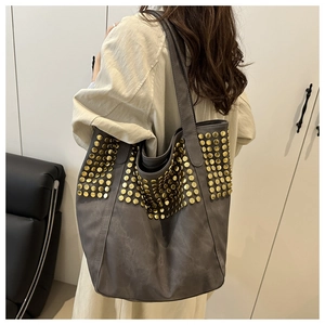 Détail du grand sac cabas avec clous dorés sur cuir suédé mat de couleur taupe foncé