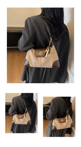 Detail of canvas tote bag with brown leather trim and golden double-ring buckle clasp