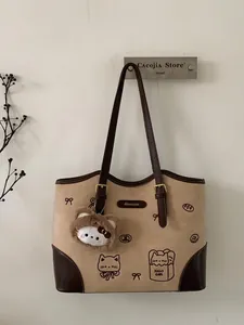 Borsa tote beige e marrone alla moda con motivi a gatto e un ciondolo Hello Kitty peluche