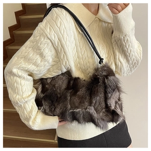 On-shoulder view of a plush fox fur shoulder bag in dark brown and grey faux fur texture