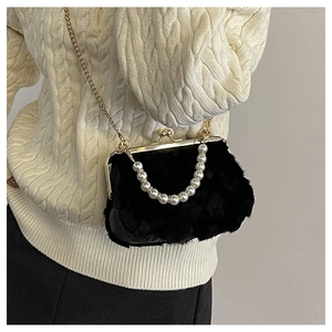 Detail of black faux fur shell bag with pearl handle and golden clasp on a knit background