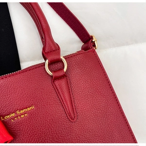 Detail of gold hardware rings and logo on red lychee pattern bridal handbag