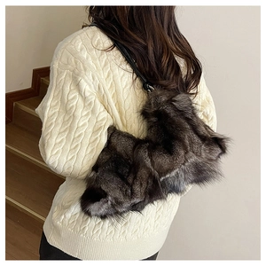 Detailed view of the luxury long faux fur texture on a shoulder bag with leather strap