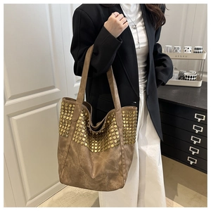 Gros plan d'un sac cabas vintage marron avec rivets dorés et style rock spacieux