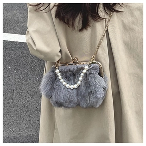 Detail of gray faux fur bag featuring a gold clasp frame and elegant pearl handle strap