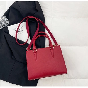 Detail of red bridal handbag with lychee texture leather and wide fabric shoulder strap