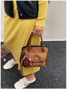 Brown suede bowling bag featuring a silver twist lock and leopard print bear charm detail