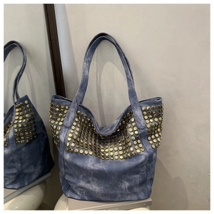 Détail du sac cabas en jean lavé avec clous dorés et finition vintage usée