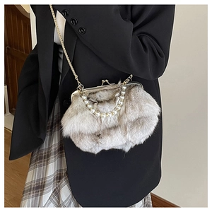 Detail view of grey faux fur shell bag with white pearl handle and gold chain strap