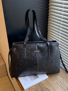 Classic black vintage leather tote bag with brand plaque and drawstring details