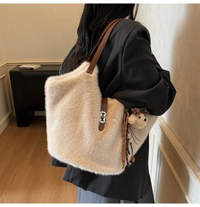 Détail du sac cabas beige en fausse fourrure avec bandoulière en cuir et charm ours