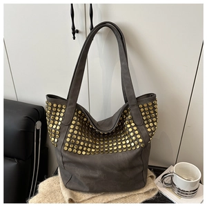 Vue détaillée du sac cabas gris foncé avec clous dorés arrondis et texture mate douce