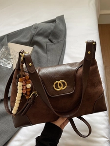Deep brown crossbody bag with suede stitching and golden double-ring buckle