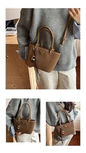 Detailed view of brown pleated bucket bag with triangle patch and wooden bead tassels
