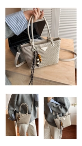 Detail of a beige quilted bucket bag featuring a wooden bead tassel and metal triangle logo