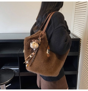 Détail du sac fourre-tout en peluche marron avec bandoulière en cuir et pendentif chiot