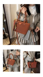 Close-up of brown quilted bucket bag with colorful bead charm and long shoulder strap