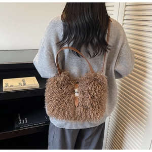 Close-up of plush faux fur bucket bag featuring a classic brown leather strap and metal buckle