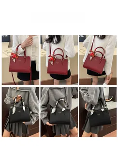 Detail view of burgundy and black pebbled leather bags with decorative silk scarves