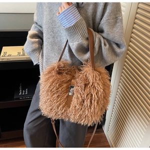 Close-up of plush brown bucket bag with leather strap and metal buckle closure detail