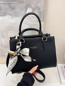 Classic black pebbled leather handbag with gold logo and silk scarf on handles