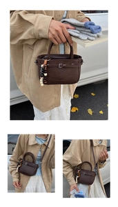 Detail of dark brown retro crossbody bag with bead charm and lychee texture