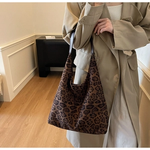 Close-up of leopard print canvas fabric and dark brown leather strap of the tote bag