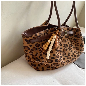 Detail der Leopard-Wildleder-Einkaufstasche mit Lederband und Holzperlen-Quasten-Anhänger