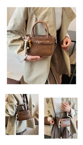 Detail view of a brown minimalist crossbody bag with boho bead charm and logo detail