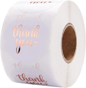 Close-up of circular rose gold thank you stickers on a roll for business packaging