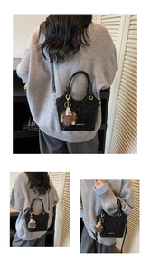 Détail du sac seau à imprimé léopard noir avec lettrage doré et charme en peluche