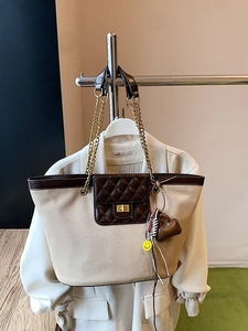 Chic beige tote bag with brown quilted pocket and golden chain straps in a hanging view