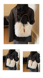 Detail of white faux fur bucket bag with brown leather strap and metal buckle