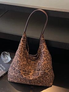 Chic leopard print large hobo shoulder bag with brown leather strap on minimalist shelf