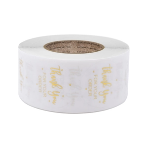 Roll of white circular Thank You stickers with gold foil lettering and heart patterns