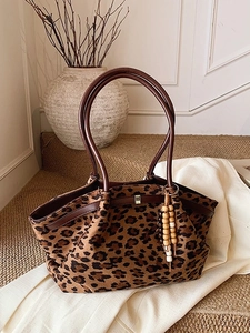 Vintage-Tragetasche mit Leopardenmuster, braunen Ledergriffen und dekorativer Quaste