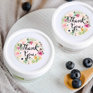 Floral Thank You sealing labels on a round container lid in a fresh rustic setting
